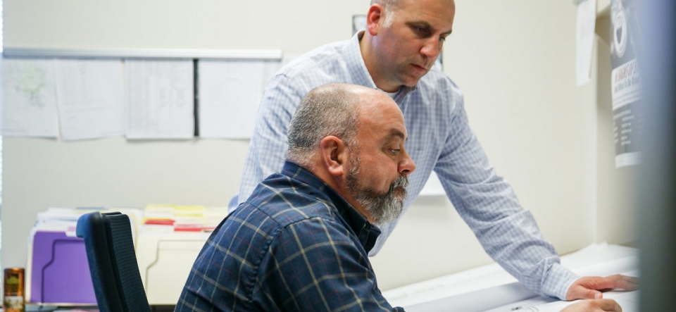 Two project managers looking at plan documents