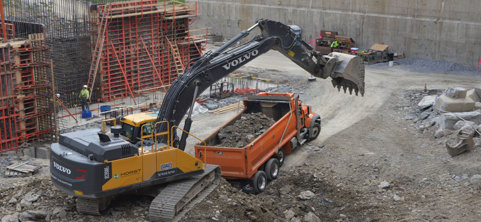 excavator filling dump truck excavating site