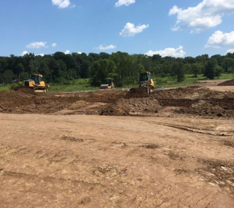 construction equipment excavating for site work at construction site