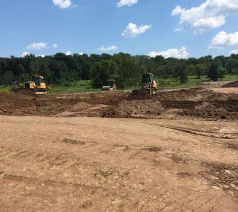 construction equipment excavating for site work at construction site