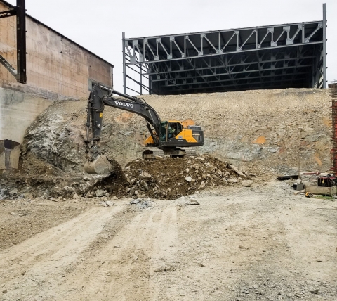 excavator on rock of rock pile