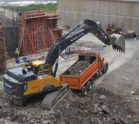 excavator filling dump truck excavating site