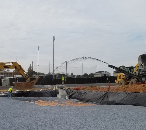 spreading aggregate at parking lot expansion