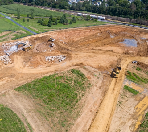 aerial of excavating equipment on large construction site