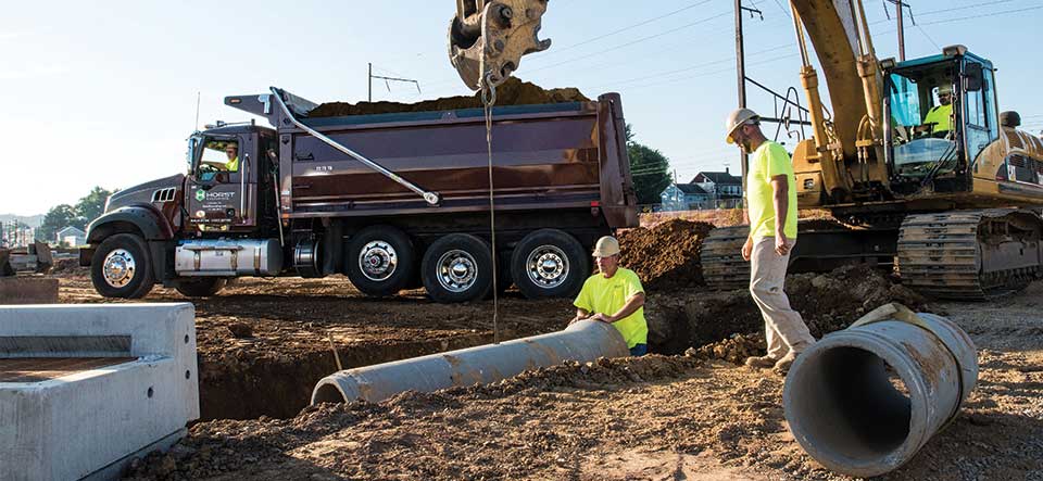 excavators laying pipe