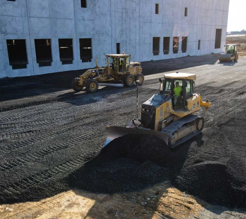 view of three paving machines preparing roadway at warehouse