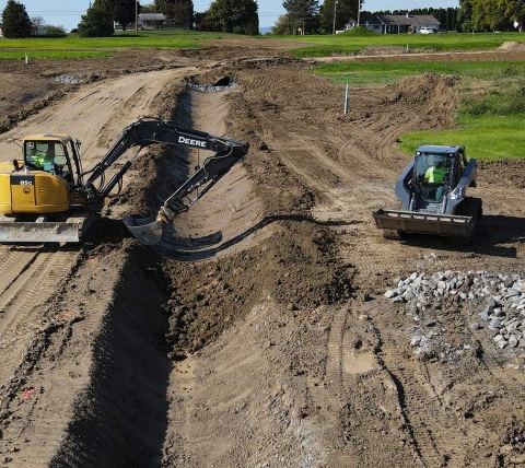 construction equipment digging trench on jobsite