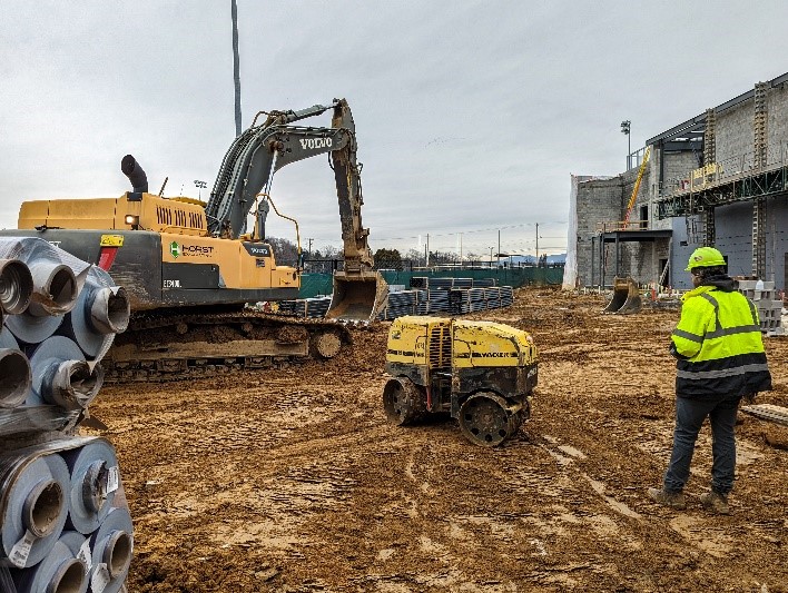 horst employee controlling walk-behind sheeps-foot roller on a job site