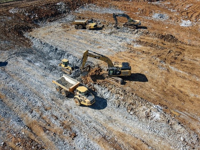 excavators and dump trucks grading site
