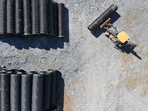 construction equipment moving black pipe